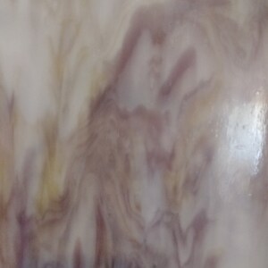 May include: A close-up of a white, brown, and purple marbled surface. The surface has a smooth, glossy finish.
