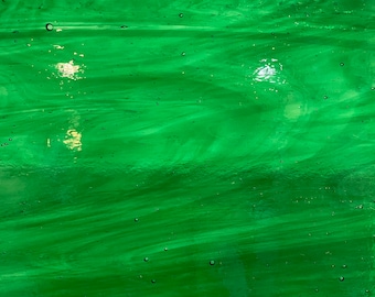 May include: A green glass sheet with a swirled pattern and small air bubbles throughout.