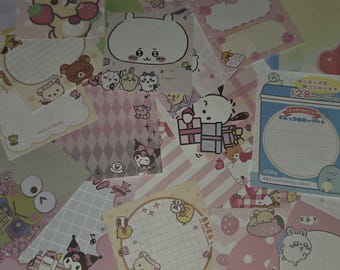 May include: A selection of patterned sticky notes with cartoon characters and strawberry designs. The notes are in various shapes, including squares, circles, and rectangles, with pink and white backgrounds. Some notes have Japanese text.