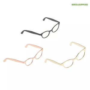 May include: Three pairs of cat-eye glasses in black, rose gold, and gold. The glasses are all the same style, but in different colors.