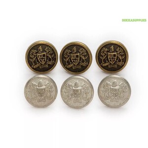 May include: Six metal buttons with a coat of arms design. Three buttons are gold with a black design and three buttons are silver with a gold design.