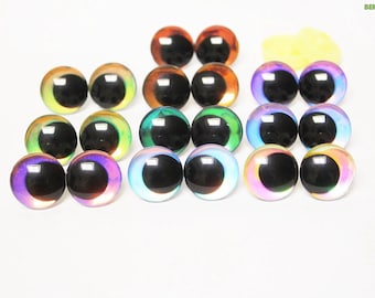 May include: A collection of colorful, iridescent glass eyes in various shades, including orange, green, purple, and blue. The eyes have a glossy finish and a black pupil. The image also includes a small pile of yellow material. The product is from BEKKASUPPLIES.