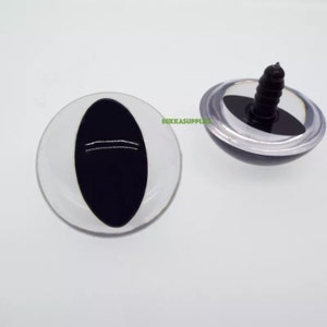 May include: Two black plastic safety eyes with a white plastic ring around the outside. One eye has a screw back for attaching to a stuffed animal or craft project.