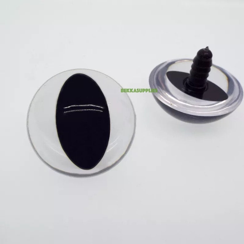 May include: Two black plastic safety eyes with a white plastic ring around the outside. One eye has a screw back for attaching to a stuffed animal or craft project.