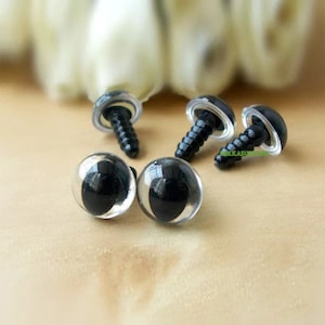 May include: Four black plastic safety eyes with clear plastic domes and screw-on backs. The eyes are different sizes.