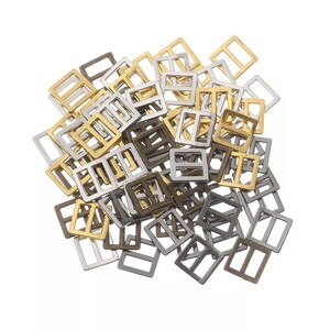 Op de afbeelding: Een stapel metalen schuifgespen in gouden, zilveren en bronzen afwerkingen. De gespen zijn vierkant met een rechthoekige opening in het midden.