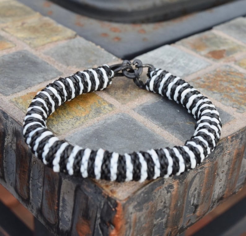 May include: Black and white striped bracelet with a metal clasp.