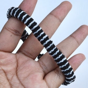 May include: Black and white striped elastic hair tie.