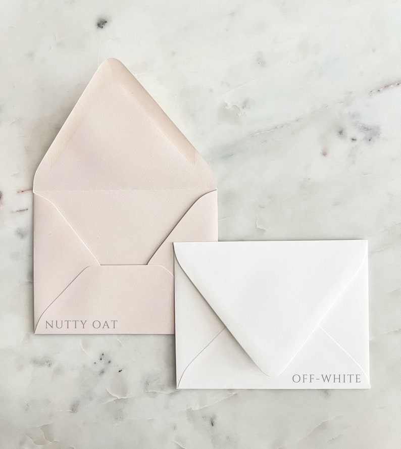 May include: Two envelopes, one open and one closed, on a marble surface. The open envelope is a light beige color with the text "NUTTY OAT" printed on it. The closed envelope is off-white with the text "OFF-WHITE".