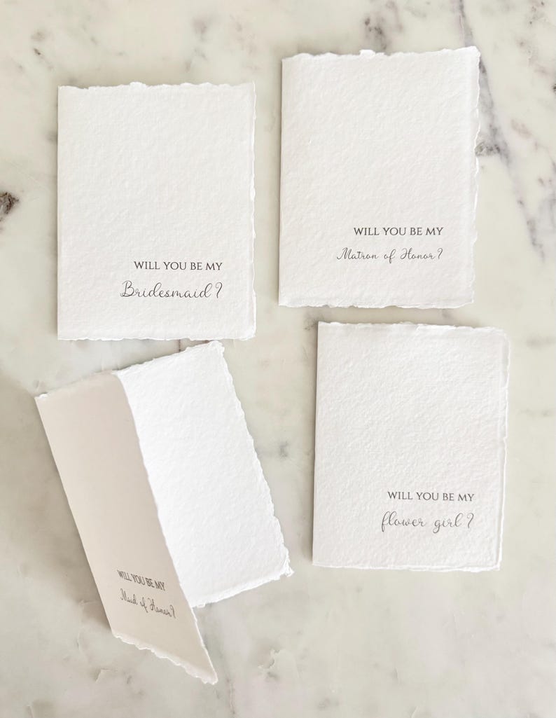 May include: A set of three ceramic mugs with a speckled, matte finish. The mugs are in shades of cream, light gray, and dark gray. Each mug has a simple, minimalist design, perfect for coffee or tea.
