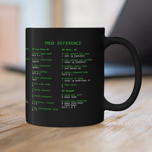 以下が含まれることがあります： 黒いコーヒーカップに白いTmux Referenceのグラフィックが描かれています。グラフィックは、黒い背景に緑色のテキストで、さまざまなTmuxコマンドとショートカットがリストされています。