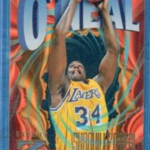 May include: A basketball trading card featuring Shaquille O'Neal in a Lakers uniform, with the number 34 on the front. The card has a blue border and a colourful background with a swirling design.