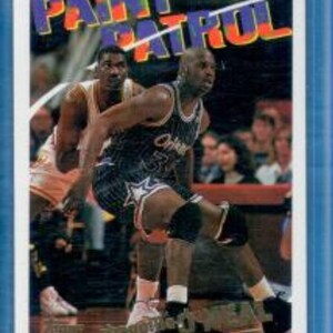 May include: A basketball card featuring two basketball players in action. The card has a blue border and the text "PAINT PATROL" in colourful letters.