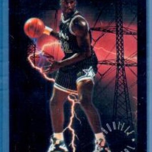 May include: A basketball trading card with a player in a black and white uniform, holding a basketball. The card has the text "FUTURE SHOCK" at the top and a lightning bolt graphic. The background is a mix of red and black.