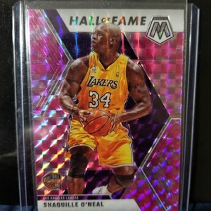 May include: A basketball trading card featuring Shaquille O'Neal in a Los Angeles Lakers uniform. The card has a holographic background with a purple and pink colour scheme. The card is labelled "Hall of Fame" and features the "M" logo for the "Mosaic" series.