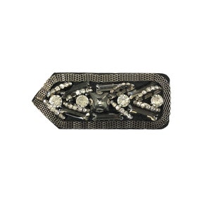 May include: A black fabric patch with a silver mesh design and clear and black rhinestones.