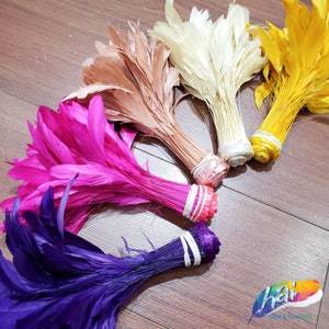 May include: Five bundles of feathers in different colors, including purple, pink, brown, white, and yellow. The feathers are tied together at the base and are arranged in a semi-circle.