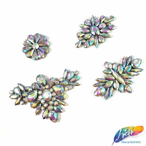 May include: Four iridescent rhinestone embellishments in various shapes and sizes. The embellishments are perfect for adding sparkle to clothing, accessories, and crafts.