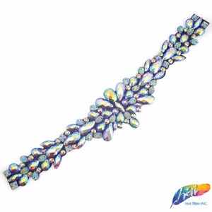 May include: A beaded trim with iridescent blue and purple rhinestones in a floral design.