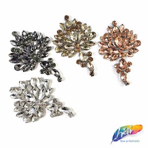 Puede incluir: Cuatro adornos de cristal en diferentes colores: transparente, plateado, dorado y dorado rosa. Cada adorno tiene la forma de un racimo de hojas.