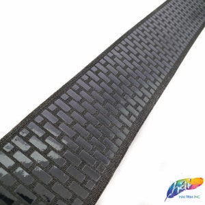 May include: Black elastic trim with a repeating pattern of small, raised squares. The trim is approximately 1 inch wide.