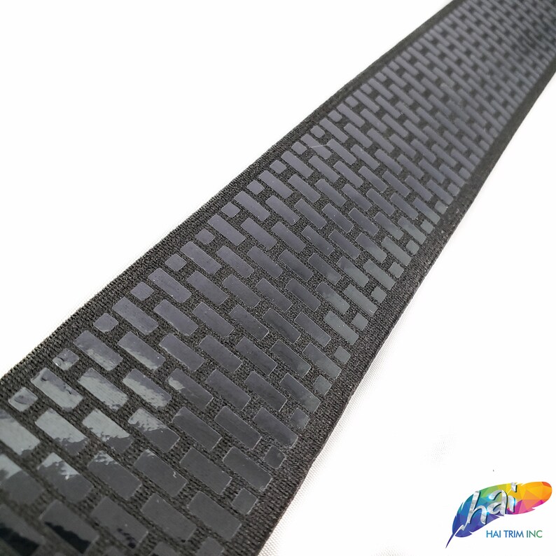 May include: Black elastic trim with a repeating pattern of small, raised squares. The trim is approximately 1 inch wide.