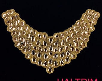 May include: Gold-colored, V-shaped trim with a dense pattern of teardrop-shaped rhinestones and smaller gold beads. The trim is set against a black background. The text "HAI TRIM" is displayed in pink.