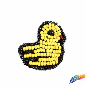 Puede incluir: Una aplicación de cuentas amarilla y negra de un pato. El pato tiene un ojo negro y un pico rojo.