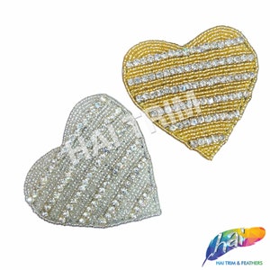 May include: Two heart-shaped beaded patches, one gold and one silver, with rows of clear rhinestones.