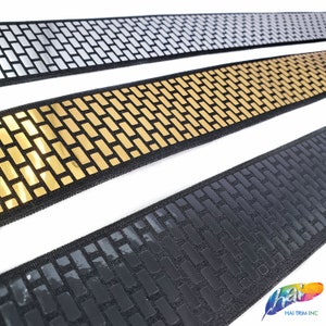 May include: Three rolls of black elastic trim with a brick pattern. The trim is available in silver, gold, and black.