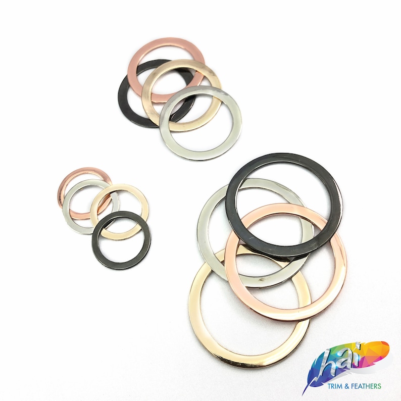 May include: Assortment of metal jump rings in silver, gold, and rose gold finishes. The rings are stacked and arranged in different sizes.