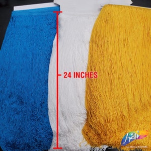 Puede incluir: Tres rollos de flecos en azul brillante, blanco y amarillo. Cada rollo presenta hilos largos y finos colgantes unidos a una cinta de cabecera. Una línea vertical roja y el texto 24 INCHES indican la longitud de los flecos.