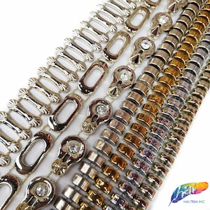 May include: Rows of decorative trim in silver, gold, and bronze tones. The trim features various designs, including open ovals, linked bars, and circular elements with clear crystal accents. The trims are arranged diagonally on a white surface.