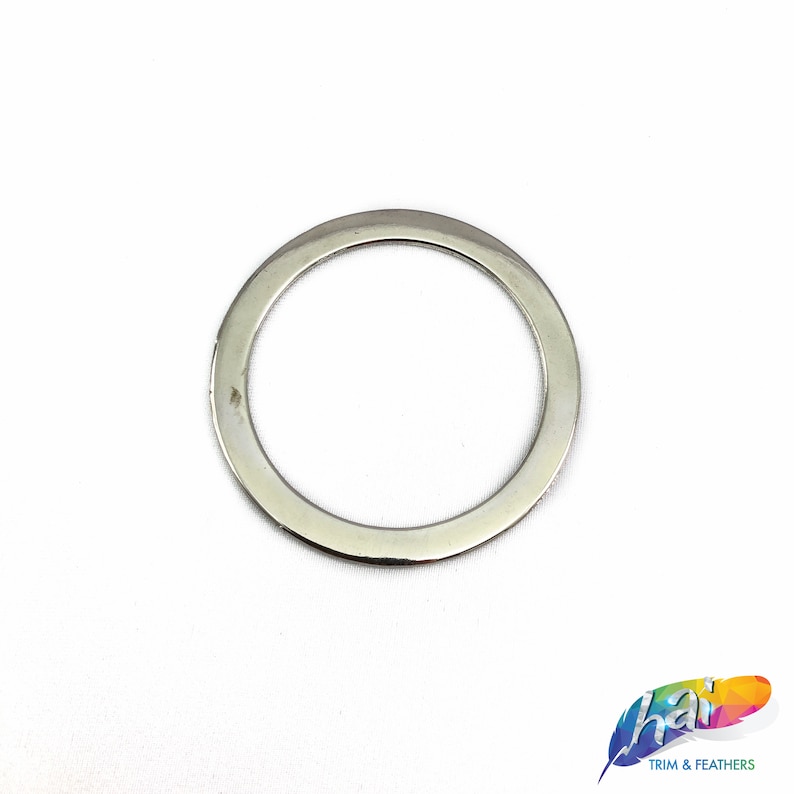 May include: A silver metal ring with a smooth, polished finish. The ring is circular and has a wide, flat band.