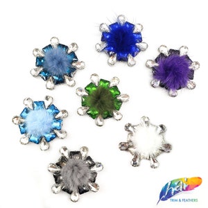 May include: Six different colored snowflake-shaped embellishments with faux fur pom-poms in the center. The embellishments are made of rhinestones and have a silver backing.