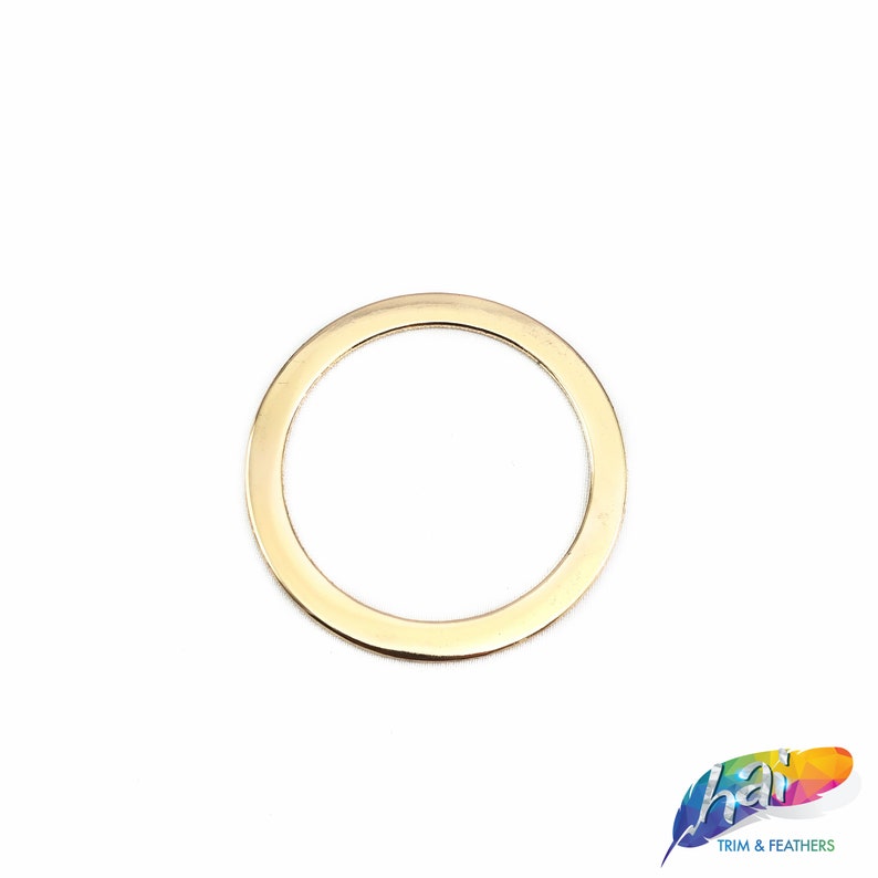 May include: A gold-colored metal ring, approximately 1 inch in diameter, with a smooth, rounded edge.