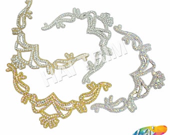 May include: Three rhinestone embellishments in gold, silver, and iridescent colors. Each embellishment features a floral design with intricate details.