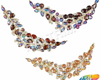 May include: Three sets of decorative embellishments featuring iridescent crystals and gold accents. The crystals are arranged in a leaf-like pattern, with a crescent shape.