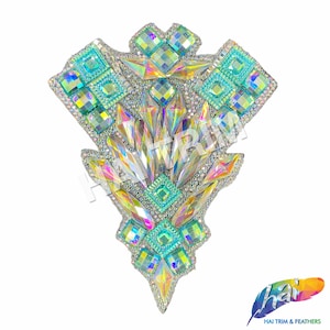 May include: A triangular-shaped rhinestone embellishment with iridescent and teal colored crystals. The embellishment is perfect for adding sparkle to clothing, accessories, or crafts.