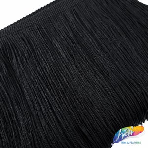 May include: Black fringe trim showing the close-up texture. The fringe is made of thin, tightly woven strands.