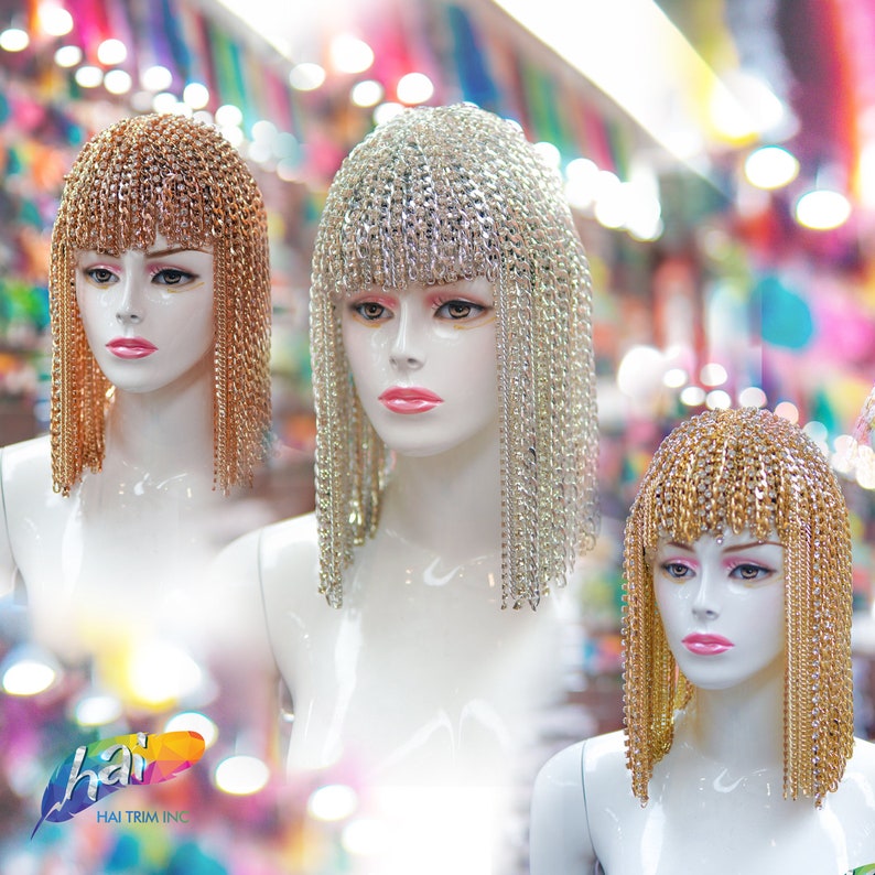 Op de afbeelding: Drie mannequins dragen verschillende stijlen gouden en zilveren kettinghoofdbanden. De hoofdbanden zijn gemaakt van metalen kettingen met kleine strass steentjes. De mannequins dragen allemaal dezelfde witte jurk.