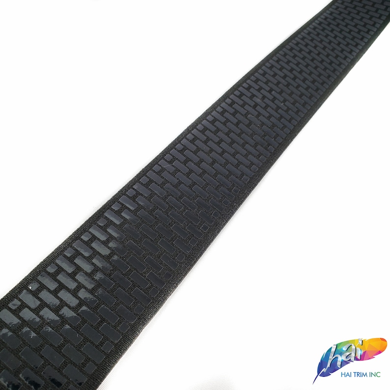 May include: Black elastic band with a repeating pattern of small, raised squares. The band is approximately 1 inch wide.