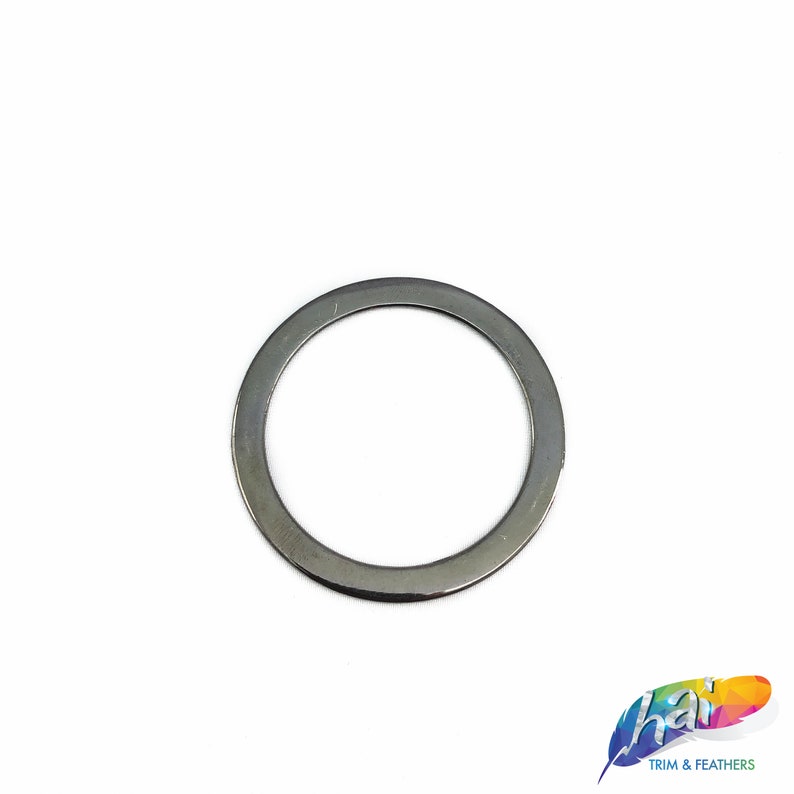May include: A silver metal ring with a smooth, rounded surface. The ring is about 1 inch in diameter.