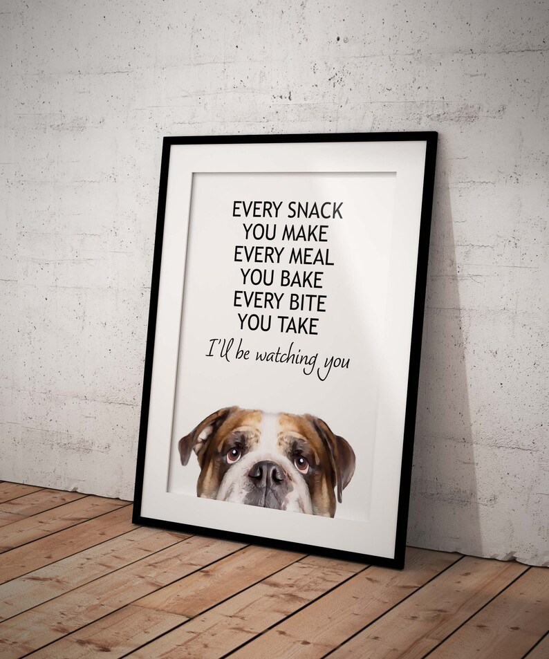 May include: A white framed print with a black and white illustration of a bulldog peeking over the top. The text reads "Every snack you make, every meal you bake, every bite you take, I'll be watching you."