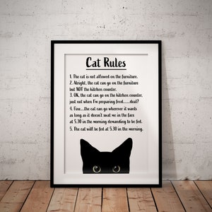 May include: A black and white printable poster with the text "Cat Rules" and a list of rules for cats. The poster features a black cat peeking out from the bottom of the frame.