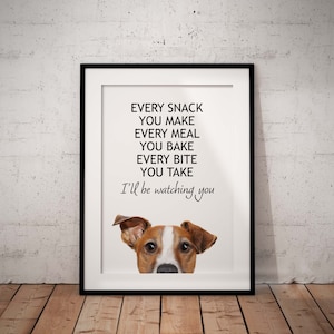 May include: A white framed print with black text that reads "Every snack you make, every meal you bake, every bite you take, I'll be watching you". A Jack Russell Terrier dog's head is peeking out from the bottom of the print.