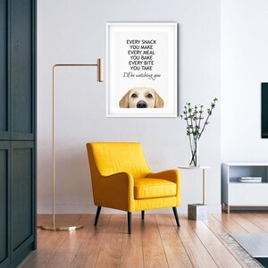 Puede incluir: Una impresi&oacute;n enmarcada en blanco con un perro Labrador Retriever amarillo mirando a la c&aacute;mara. El texto en la impresi&oacute;n dice "Every snack you make, every meal you bake, every bite you take, I'll be watching you."