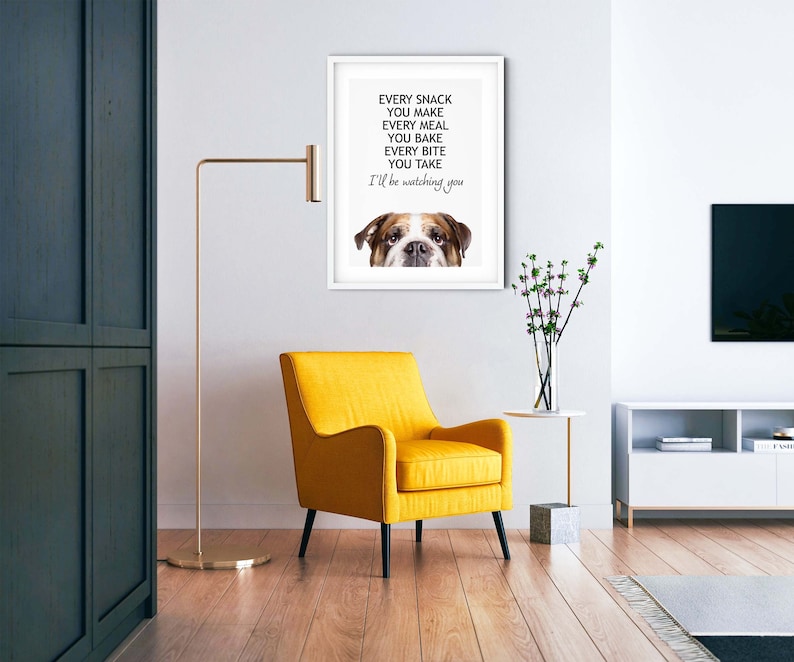 May include: A white framed print with a bulldog's face peeking out from the bottom. The text reads "Every snack you make, every meal you bake, every bite you take, I'll be watching you."