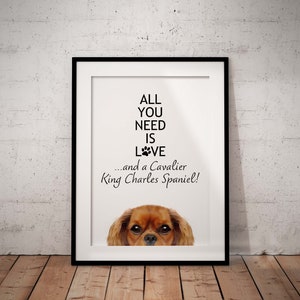 May include: A white framed print with the text "All you need is love... and a Cavalier King Charles Spaniel!" with a Cavalier King Charles Spaniel peeking out from the bottom of the frame.