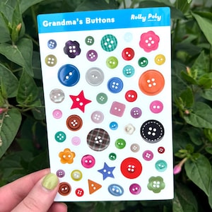 May include: A sheet of colorful buttons in various shapes and sizes, including round, star, and flower designs. The sheet is labeled "Grandma's Buttons" and "Rolly Poly". The buttons are in shades of blue, green, red, orange, and brown.